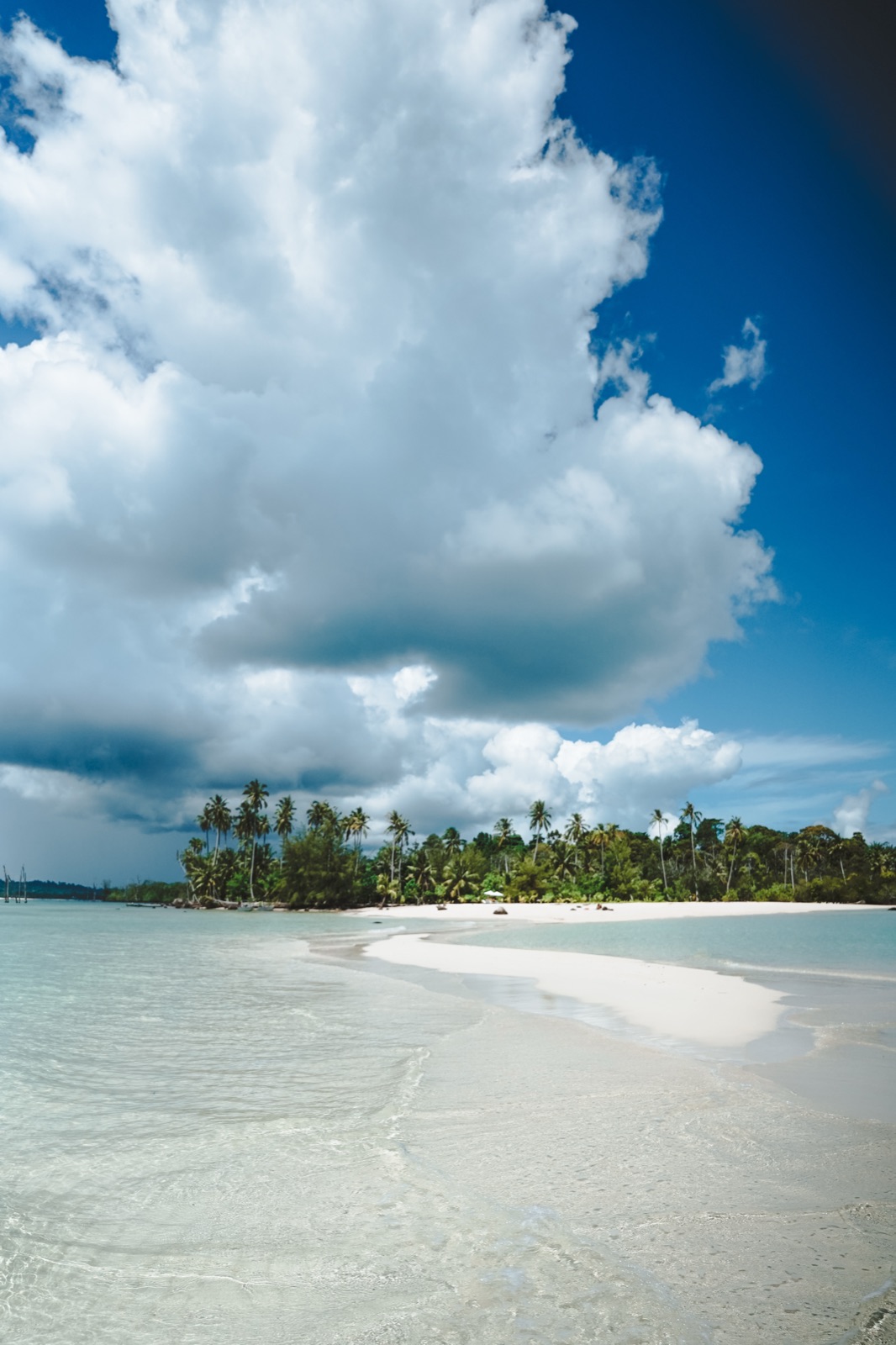 Dramatic storm clouds over a white sand beach in the Mentawai Islands